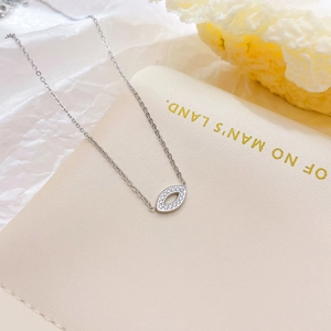 Elegant silver Evil Eye necklace with crystal inlay on a minimalist book background