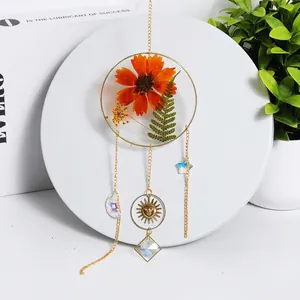 Handmade sun catcher with dried orange flower, celestial gold charms and crystal prism