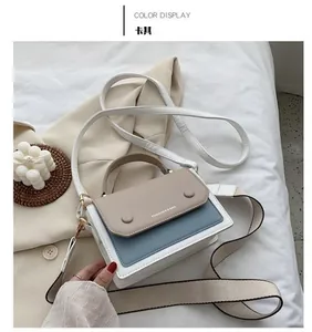 Detail of color-block flap bag in khaki, blue and white with wide shoulder strap