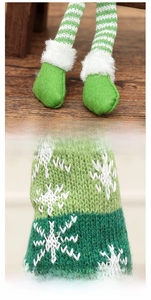 Detail of Christmas gnome showing striped legs and snowflake knit pattern on wood