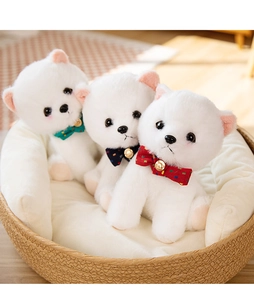 Detailed view of three white Pomeranian plush toys with colorful polka dot ribbon bells