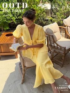 Detail of a bright yellow two-piece summer set with V-neck tie-front top and long skirt