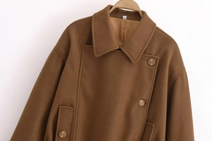 Detail of classic lapel and double-breasted buttons on brown wool coat for women