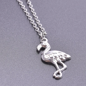 Macro view of a silver flamingo pendant necklace with detailed feather textures on O-chain