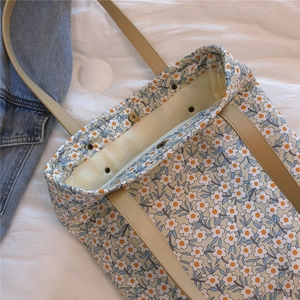 Vue détaillée du fermoir magnétique en métal et de la bandoulière en cuir du sac