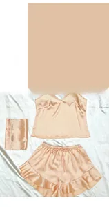Detail of silk satin pajama set featuring a V-neck camisole and ruffle shorts with drawstring