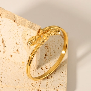 Detailed view of gold plated stainless steel knot bracelet with spiral texture on stone