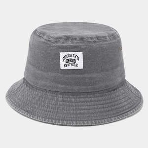 Détail d'un chapeau bob vintage gris en toile lavée avec écusson Brooklyn et œillets métalliques