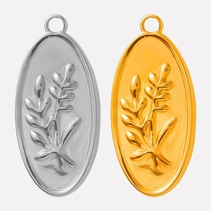 Macro detail of oval stainless steel pendants in gold and silver with embossed floral branch