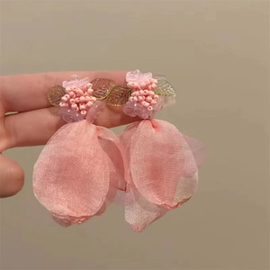 Detailed close-up of handmade pink fabric flower earrings with delicate pearl bead accents