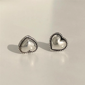 Macro shot of 925 sterling silver heart studs featuring textured twisted rope edges