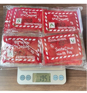 Detailed view of red Christmas felt envelope bags on a scale showing 195.1g product weight