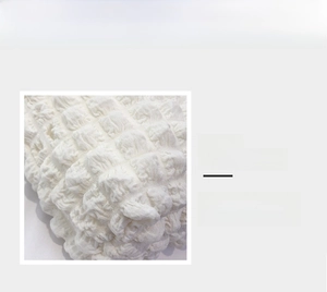 Detail view showing textured puff fabric and 3D pleated surface of the white shoulder bag