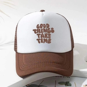 Detail of the GOOD THINGS TAKE TIME printed text on brown and white mesh trucker hat