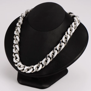 Hip hop style silver Cuban chain necklace with white ceramic links on a black bust display
