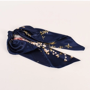 Dettaglio di scrunchie foulard in raso blu navy con elegante stampa peonia bianca
