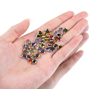 Colorful heart crystal pendants in gold and silver frames shown on a palm for size