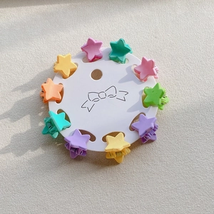 Detailed view of 10-piece star-shaped macaron mini hair claws on a round display card