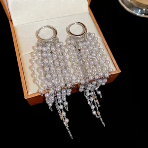 Elegant 18k gold plated hoop earrings with long pearl tassels on a jewelry box