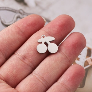 Polished silver cherry pendant charm made of stainless steel displayed on a hand