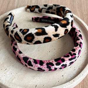 Detail of yellow and pink velvet leopard print headbands with a handmade label inside