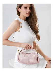 Detail of light pink woven leather handbag featuring a ruched handle and golden hardware