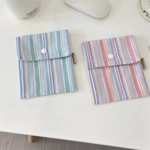 Close-up of striped fabric sanitary pad pouch with snap closure and side label detail