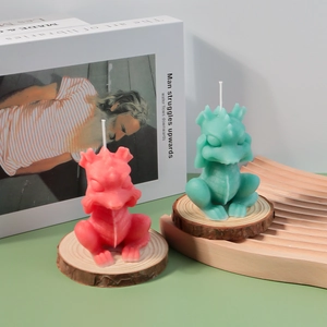 Detail of cute dinosaur scented candles in red and green on wooden coasters