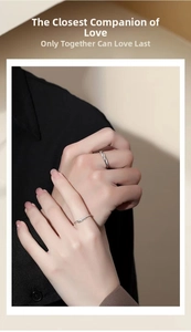 Detail of silver couple rings with feather carving and twisted rope texture on fingers