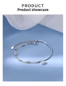 Detail of silver dual-layer star bracelet with flower pendant and adjustable chain