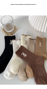 Detail of multi-color knitted cotton socks with cute rabbit embroidery and ribbed cuffs