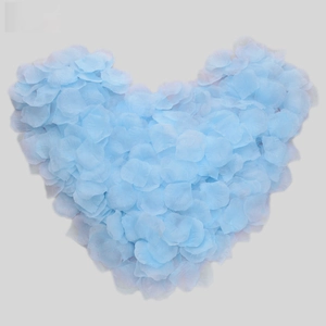 Macro view of light blue artificial rose petals arranged in a heart shape for weddings