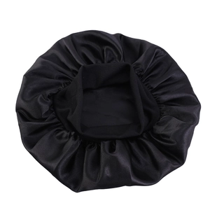 Macro shot of black satin silk sleep cap showing smooth texture and elastic band detail