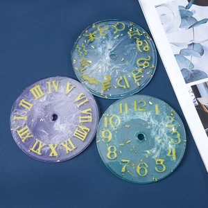 Detalle de moldes de resina para reloj DIY con números romanos y láminas de oro