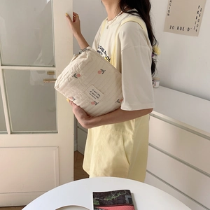 Quilted beige stroller bag with pink tulip embroidery and zip closure detail