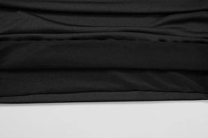 Détail du tissu en maille noire montrant la texture fine et les coutures de la robe