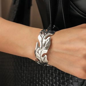 Detailed close-up of a wide silver leaf cuff bracelet with realistic vein textures