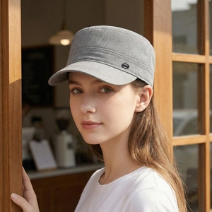 Men's grey flat top sun hat in twill fabric worn by a male model in warm outdoor setting