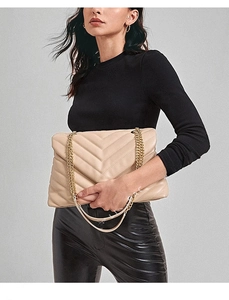 Detailed view of beige quilted handbag with V-shaped stitching and golden chain strap