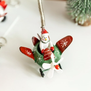 Handcrafted metal snowman in green airplane Christmas ornament with spring hook hanging