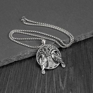 Detailed close-up of a silver Viking raven and Tree of Life pendant on a box chain