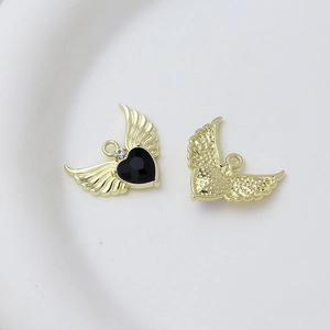 Detailed close-up of golden heart angel wing pendant with black faceted stone and zircon