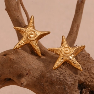Detailed macro view of 18K gold-plated starfish earrings with textured swirl finish
