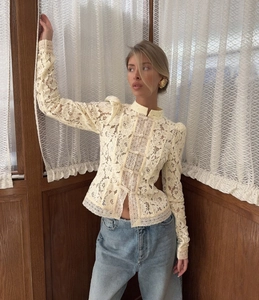 Detalle de elegante blusa de encaje beige con botones de nudo tradicional chino
