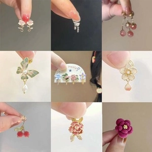 Close-up collage of elegant flower, butterfly and cherry earrings in diverse colors