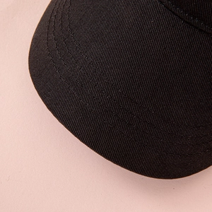 Detailed close-up of parallel stitching on black twill cotton baseball cap brim