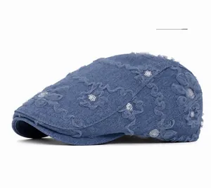 Detail of deep blue denim beret with elegant floral lace and shimmering silver sequins