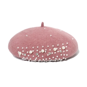 Close-up of pink wool beret featuring elegant white pearls and sparkling rhinestone details