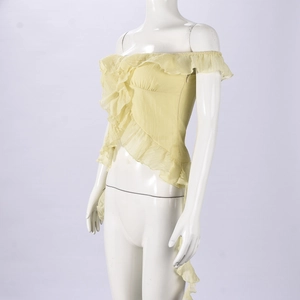 Detail showing tiered ruffles and light yellow fabric of the off-shoulder crop top