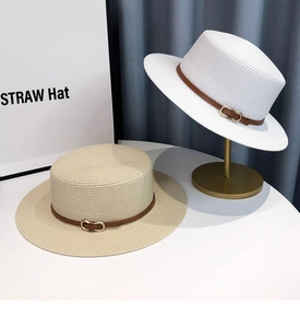 Detail view of woven boater straw hats with leather bands and gold metal buckles